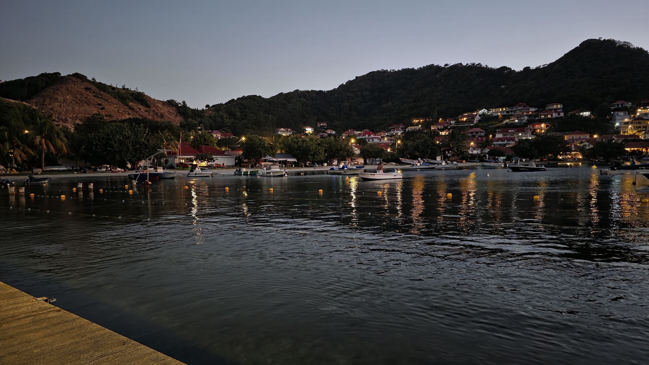 Lumières du bourg se reflétant dans la baie à la tombée de la nuit