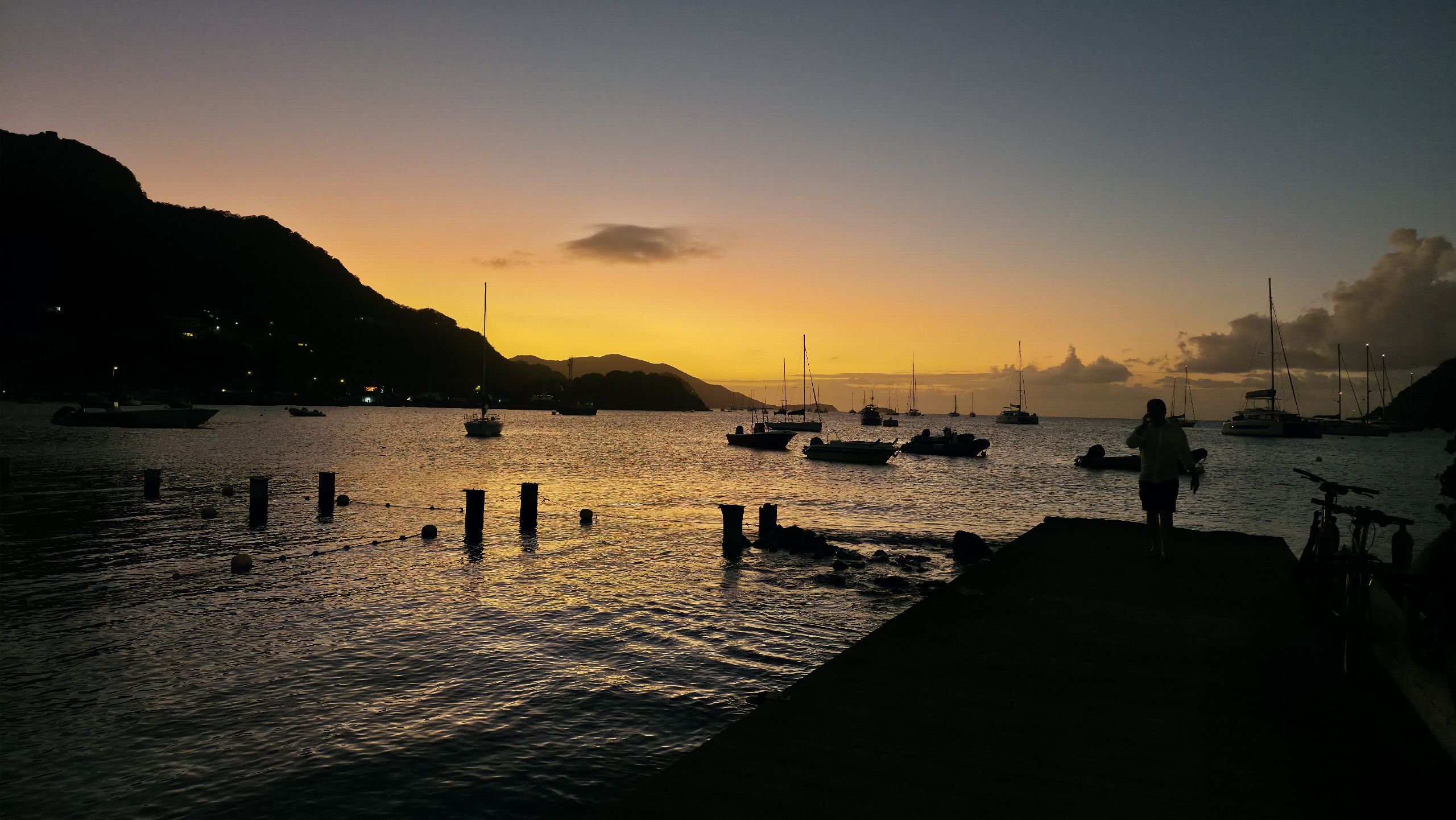 Silhouette sur un ponton face au coucher de soleil sur la baie