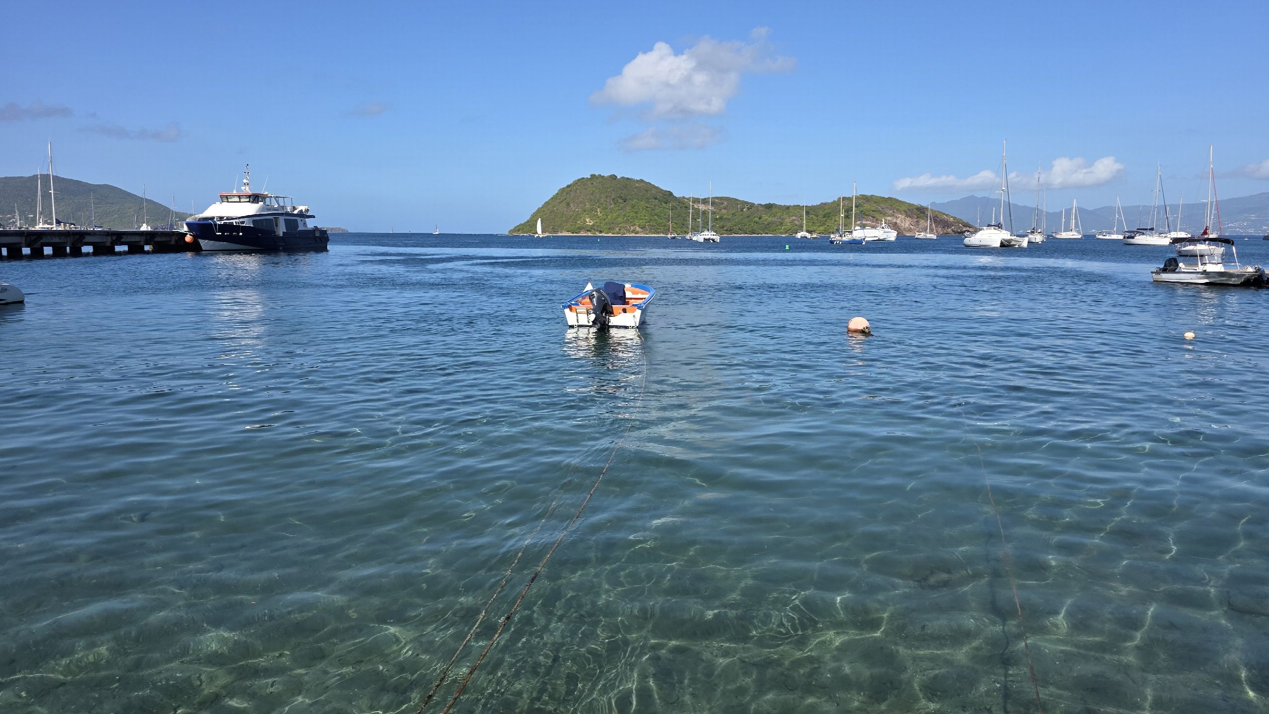 Navette maritime et petites embarcations sur une mer turquoise